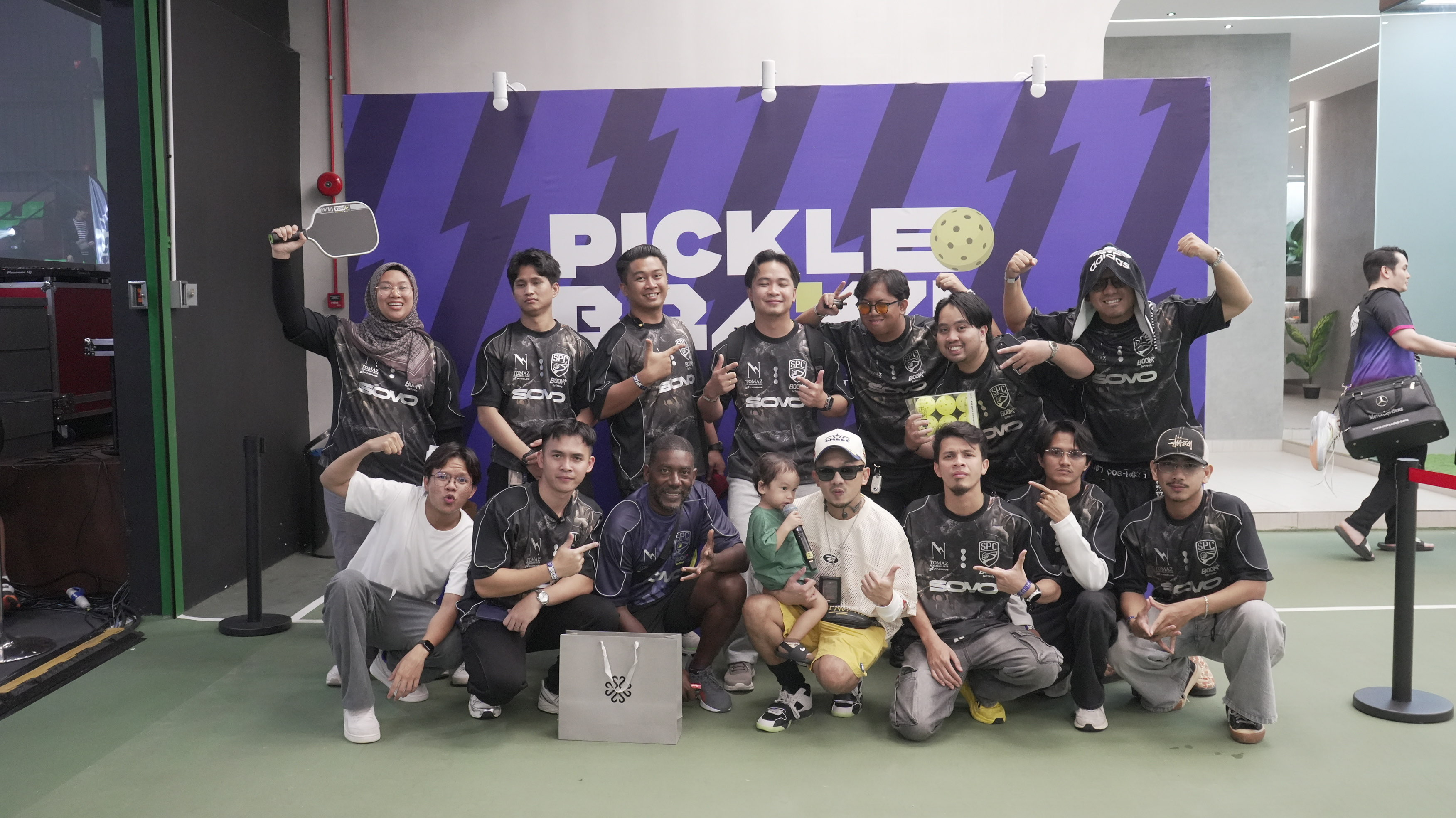 Picklebrawl group posing together in front of the purple event backdrop